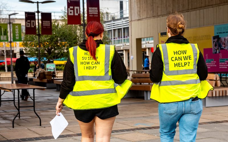 essex su staff wearing "how can I help" hi-vis