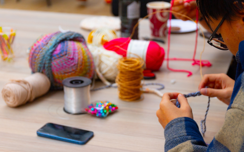 Essex student crocheting in  the Atrium