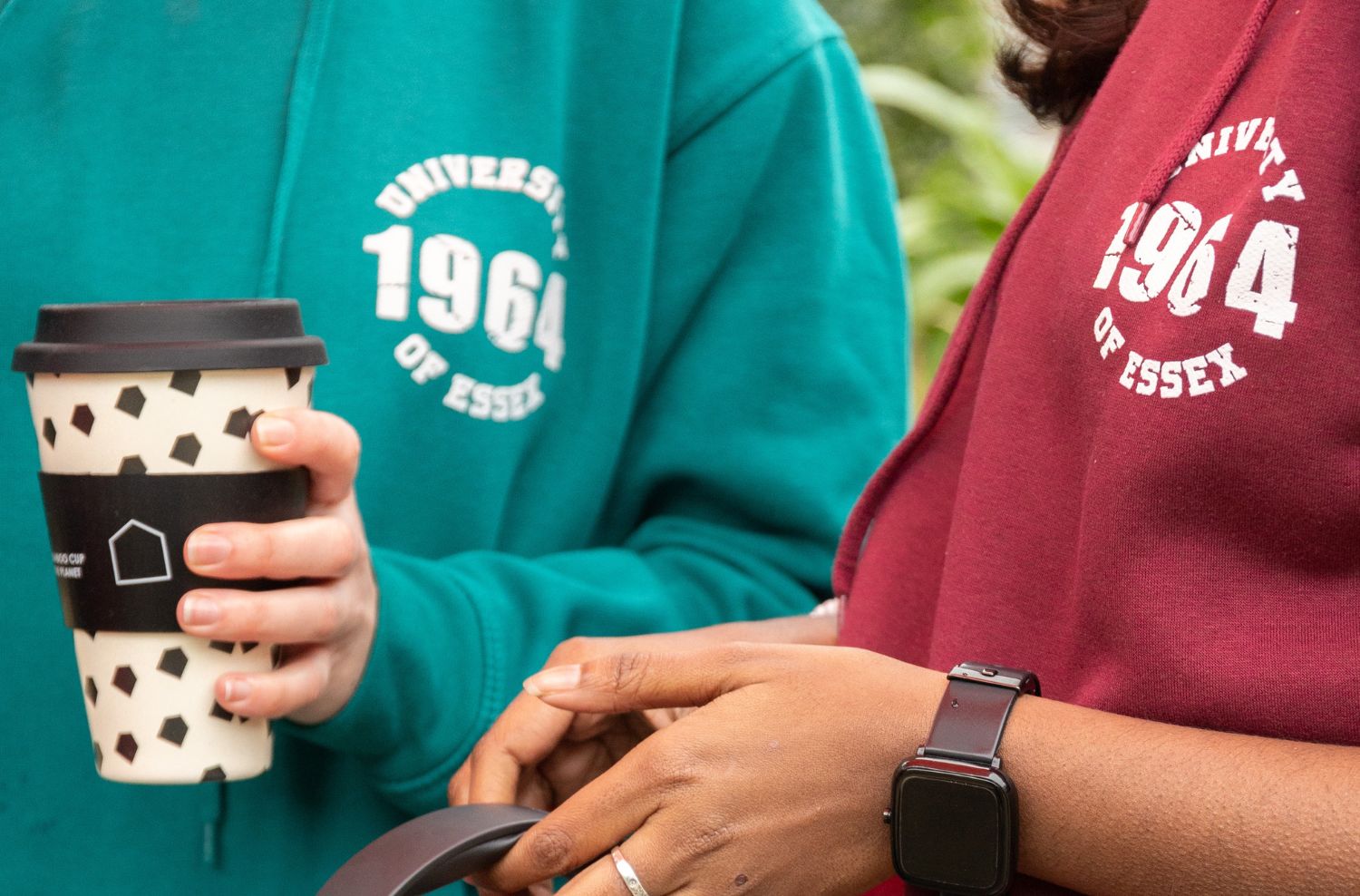 Two essex students holding an SU coffee cup