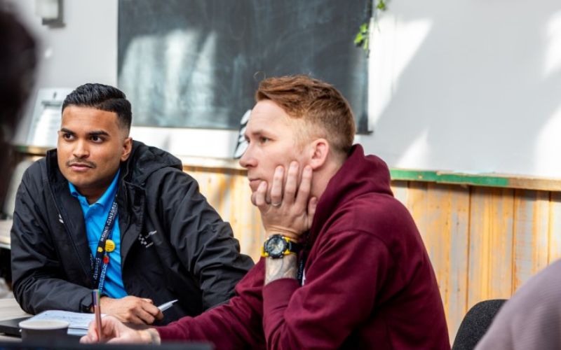 Two essex members talking notes 