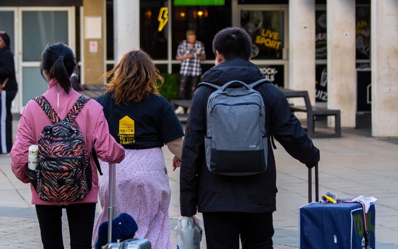 Essex students with suitcases being shown around